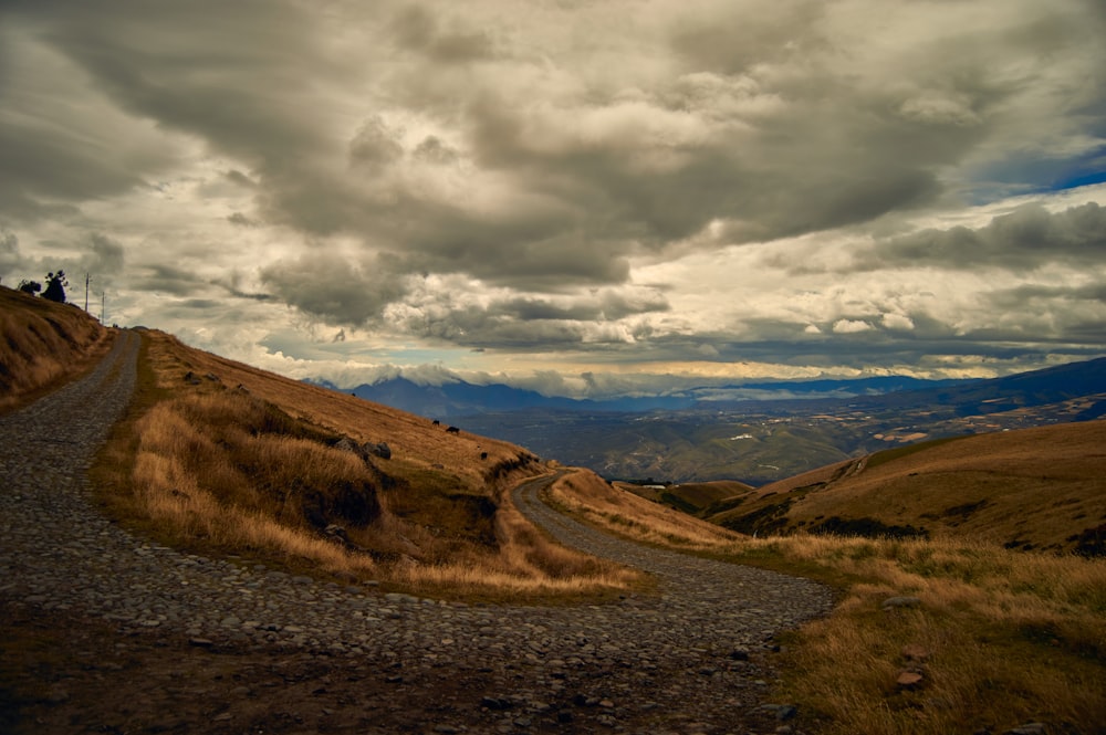 a person riding a bike on a dirt road in a hilly landscape