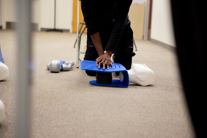 a rescuer performs chest compressions on a dummy without interruption