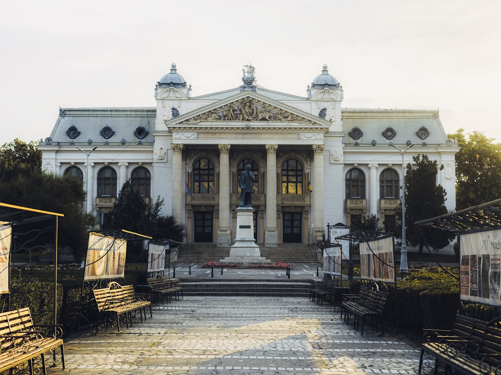 un grand bâtiment blanc avec une fontaine devant lui