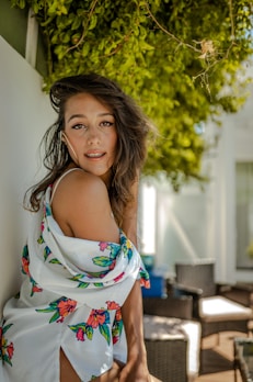 Casual women's summer dress hanging outdoors with sunlight filtering through leaves.