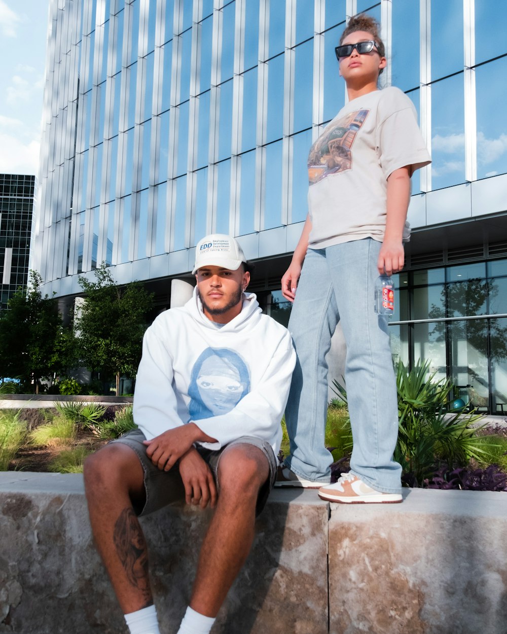 a man and a woman sitting on a stone ledge in front of a building