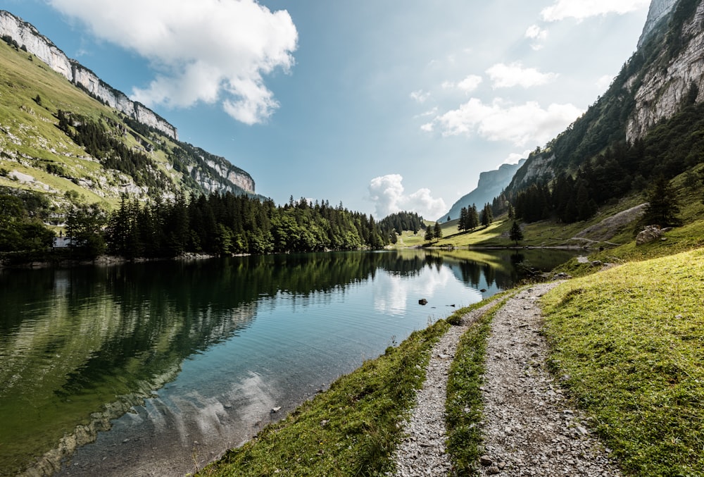 a river with a trail and mountains