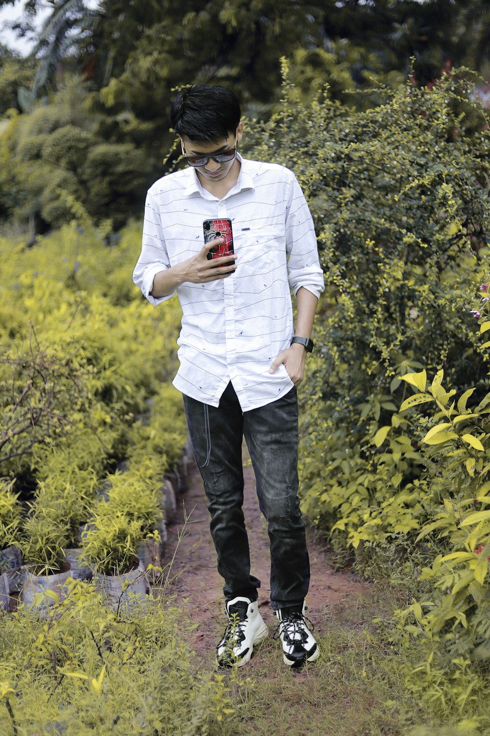 a man wearing a white shirt and black headphones holding a red and white cup