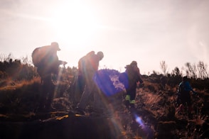 a group of people with backpacks walking on a dirt path