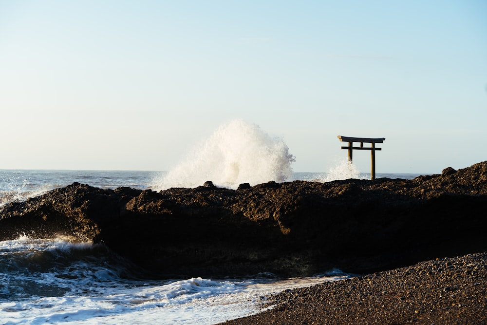 a small wooden structure on a rocky cliff by the ocean