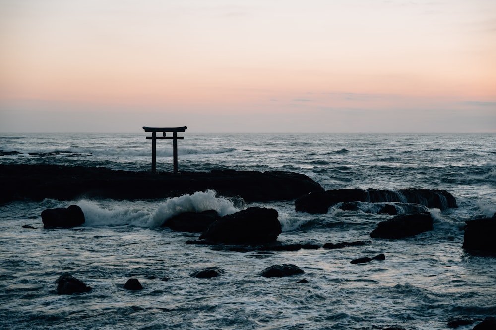 a body of water with rocks and a structure in the middle