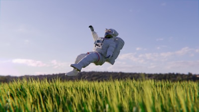 An astronaut in a white space suit is floating above a field of green grass. The sky is clear with a few scattered clouds, and there’s a distant line of trees in the background. The scene combines elements of space exploration with nature, creating a surreal and dreamlike atmosphere.