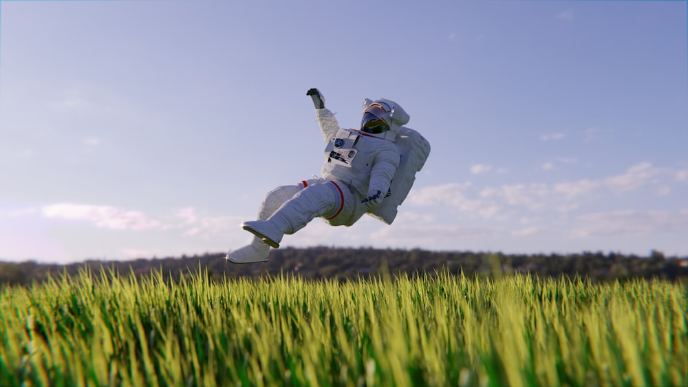 uma pessoa em um terno branco pulando em um campo de grama