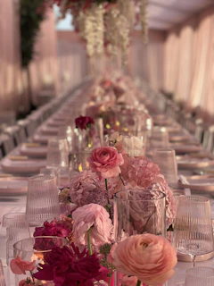 Elegant event table centerpiece featuring metallic-toned satin ribbon roses glowing under soft lighting