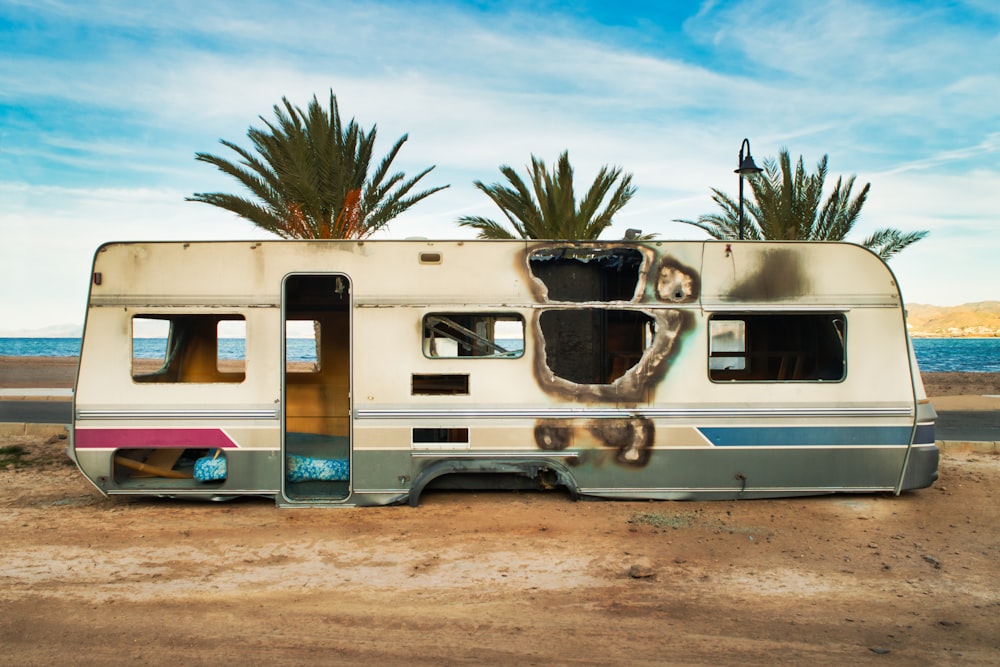 a white rv on a sandy beach