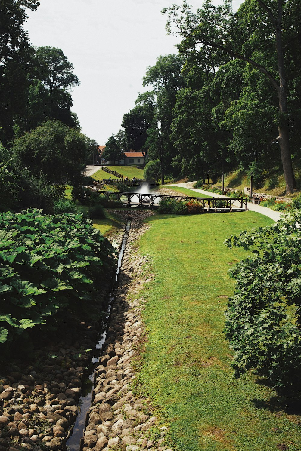 un chemin de pierre avec un mur de pierre, de l’herbe et des arbres