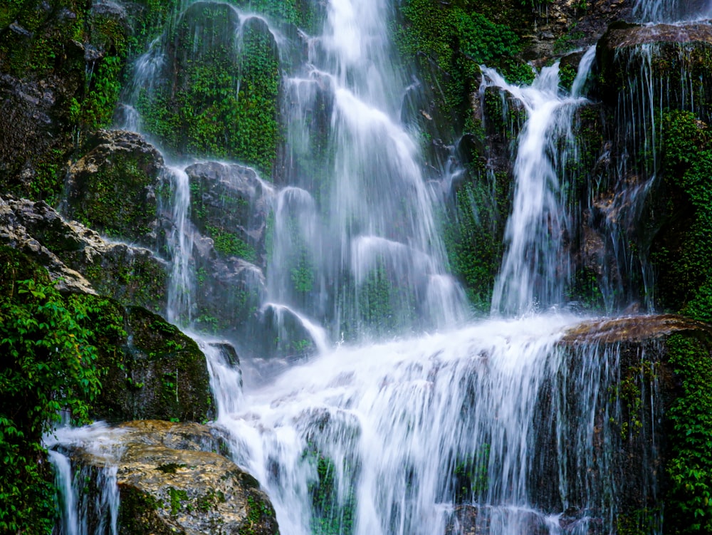uma cachoeira com pedras e musgo