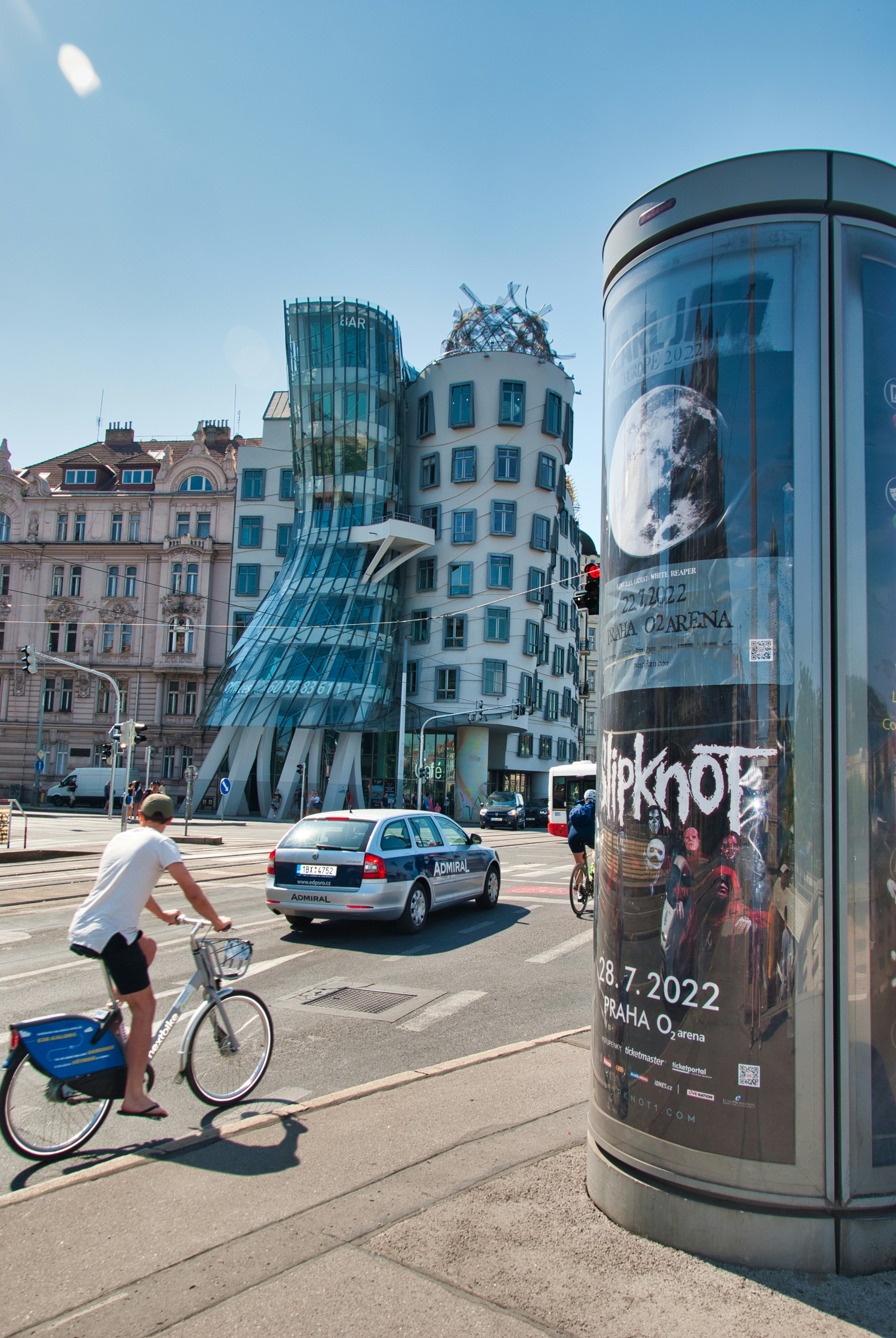 une personne qui fait du vélo sur un trottoir à côté d’un immeuble