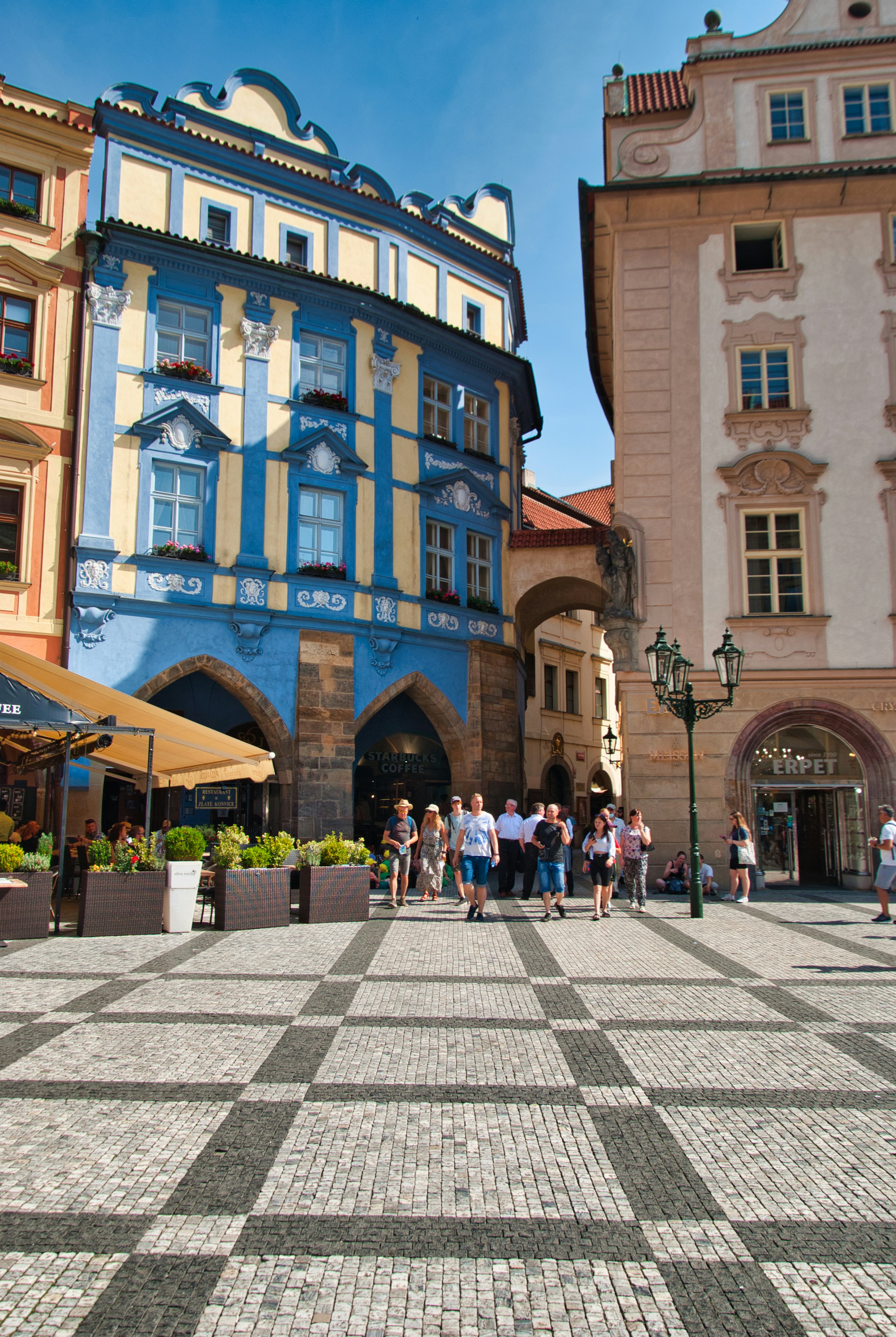 Un grupo de personas caminando por una calle entre edificios