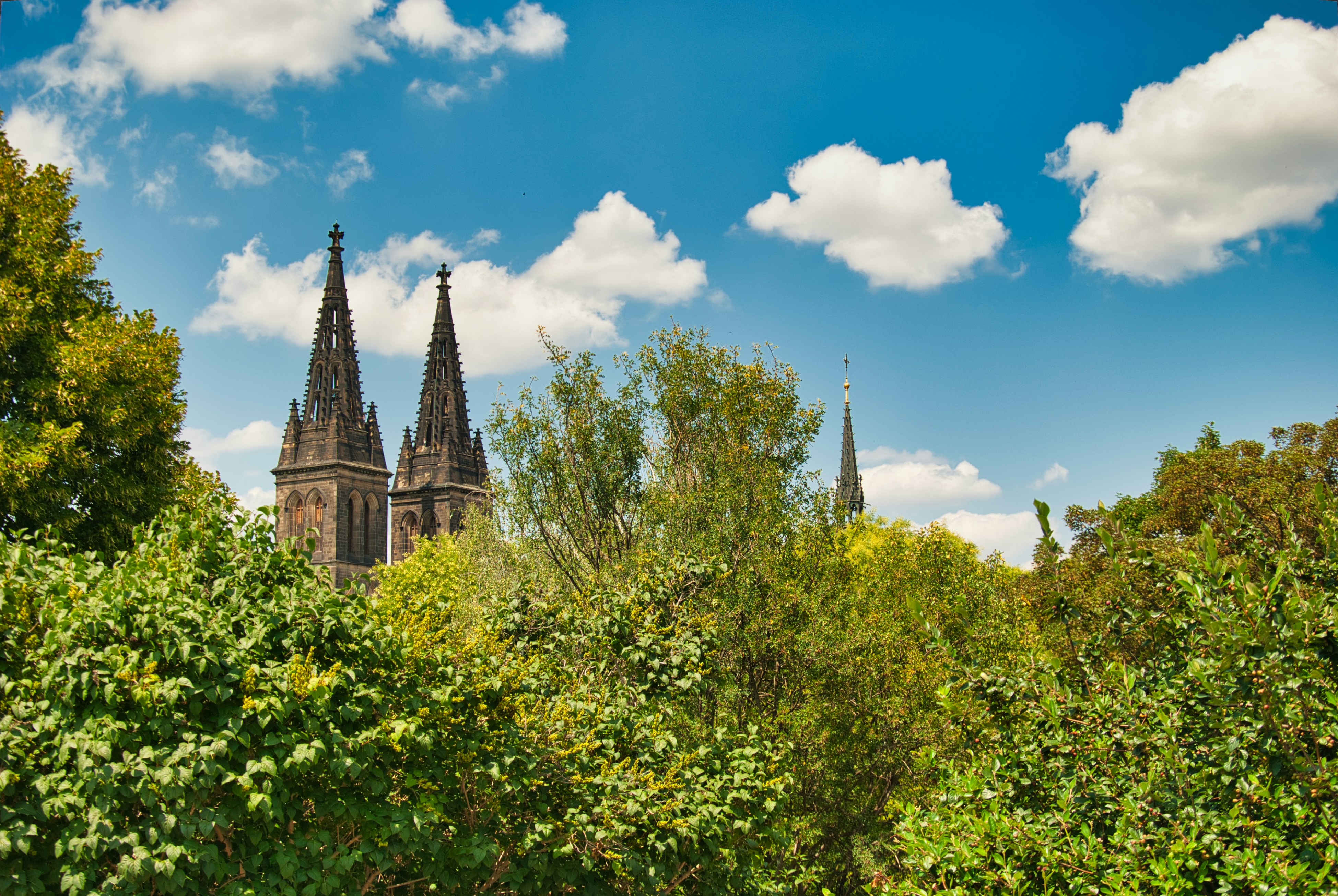 a building with spires behind trees