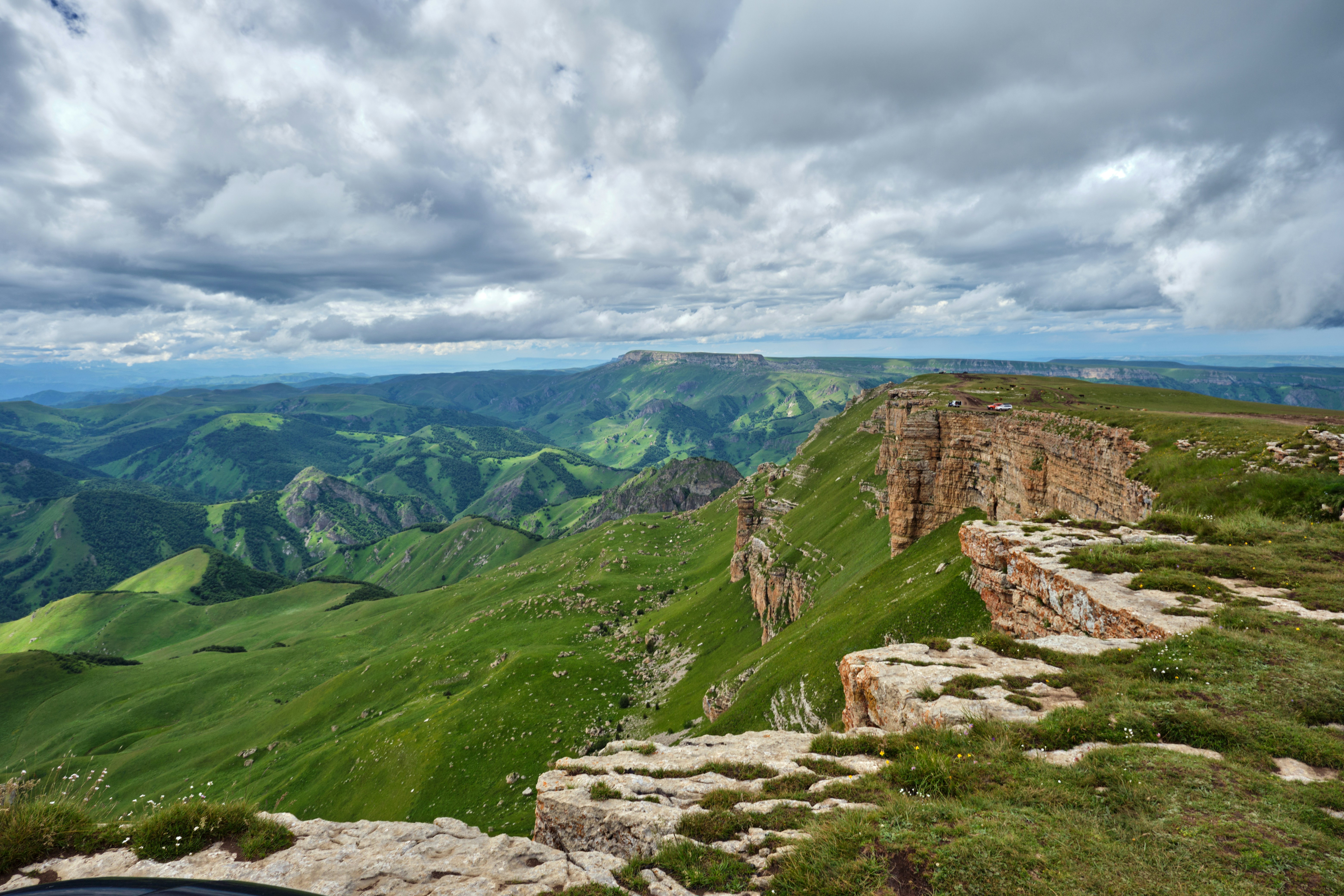 a rocky cliff with a valley below