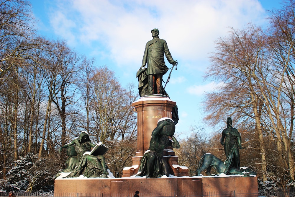 a statue of a person holding a spear and a group of people