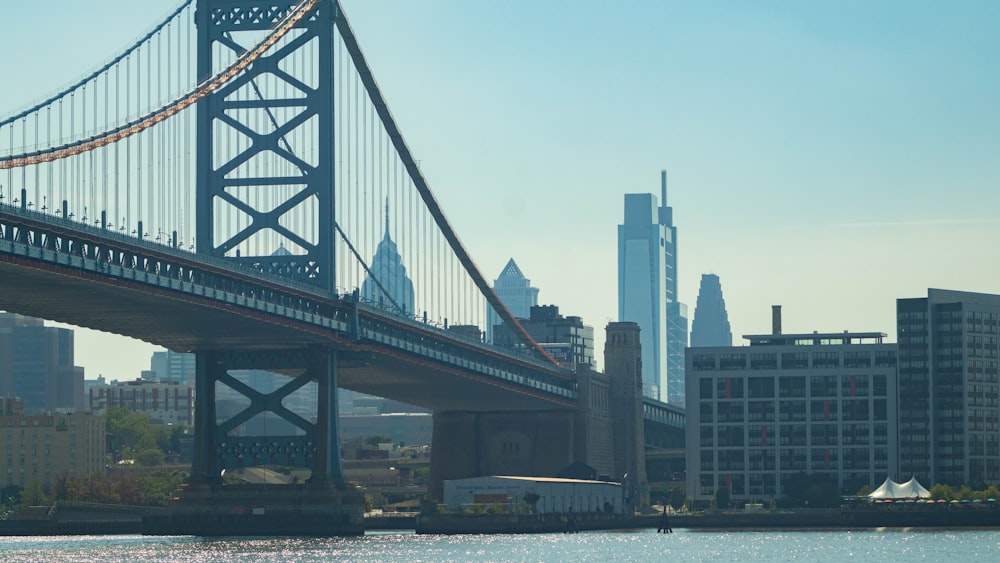 a bridge over water with buildings in the background