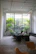 An architect reviewing blueprints in a bright office filled with plants and natural light.