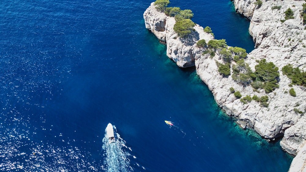 a body of water with white rocks and trees on the side