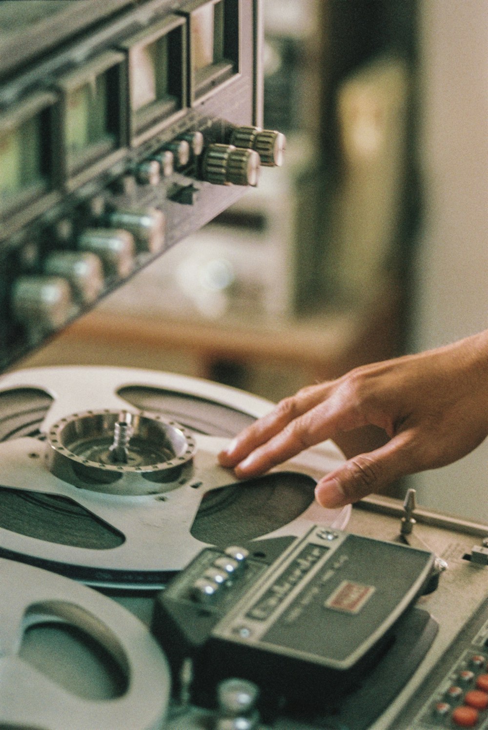 a hand pointing at a record player