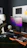 Professional cleaner wiping a modern office desk with purple accents in the background.