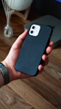 Close-up of hands holding a smartphone with a stylish adlora case in a bright, modern setting