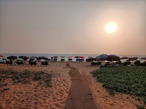 A serene beach scene with massage tables lined up facing the sea at sunset