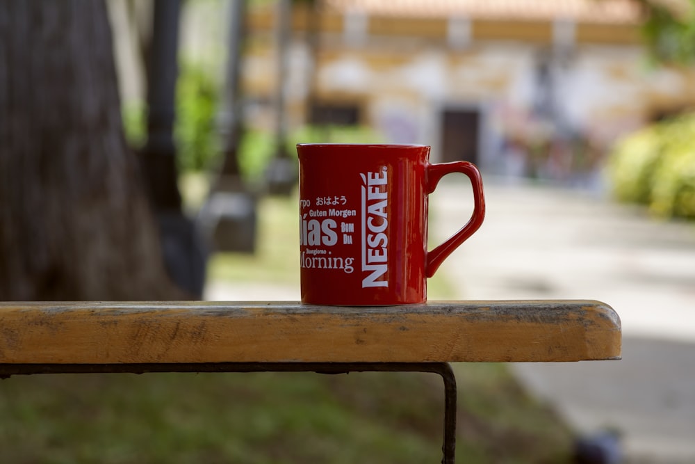 a red mug on a bench