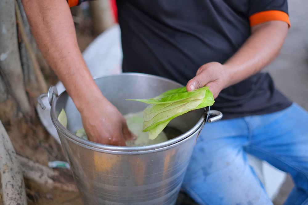 a person holding a leaf in a bucket