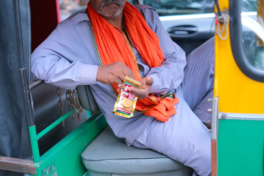 Un homme en gilet orange tenant une boîte de bonbons