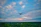 A happy customer flying a drone over a forested area during sunset.