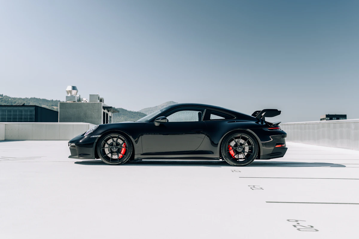 Black Porsche 911 GT3 side profile in soft light