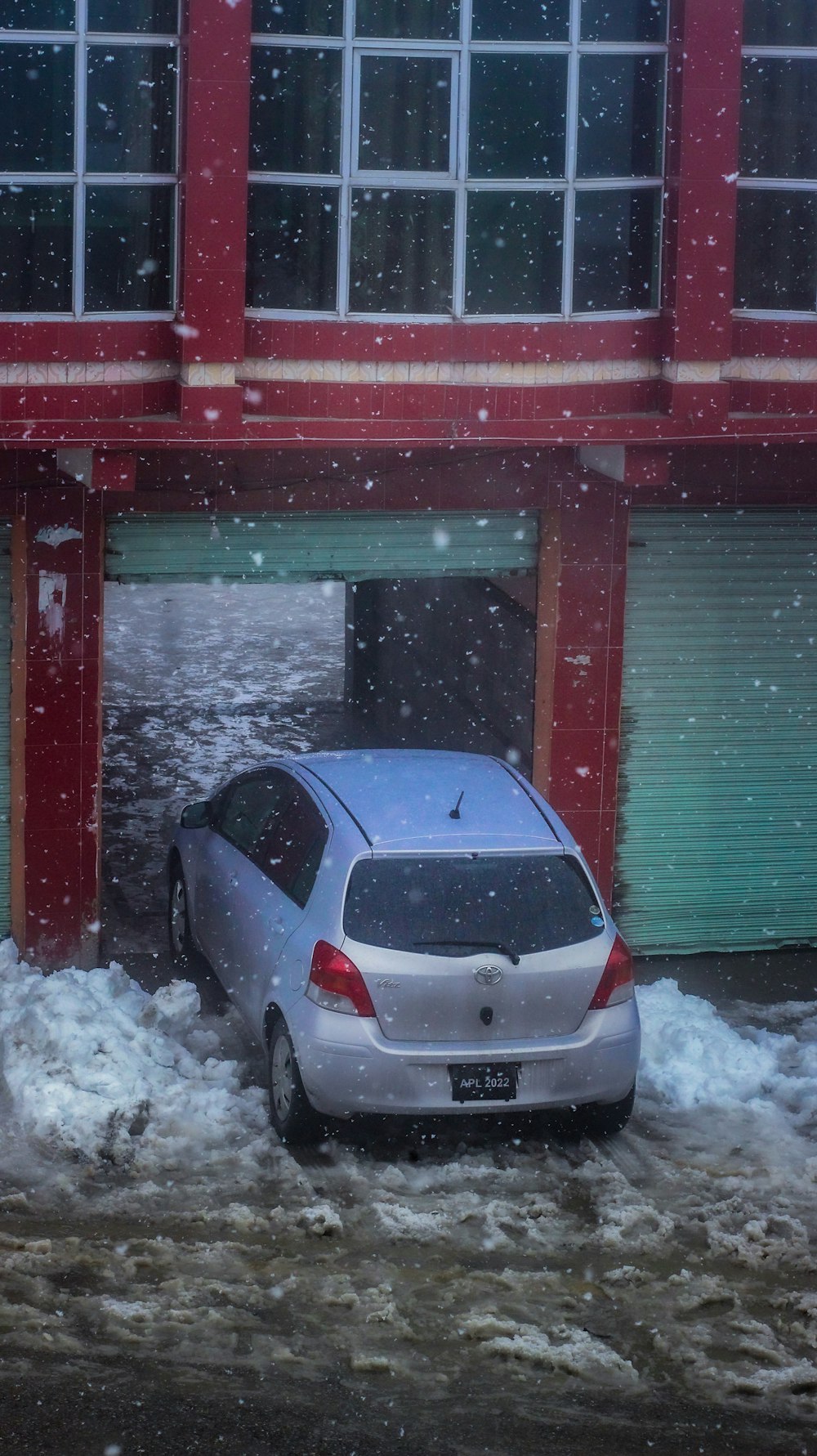 a car parked in front of a building with snow on the ground