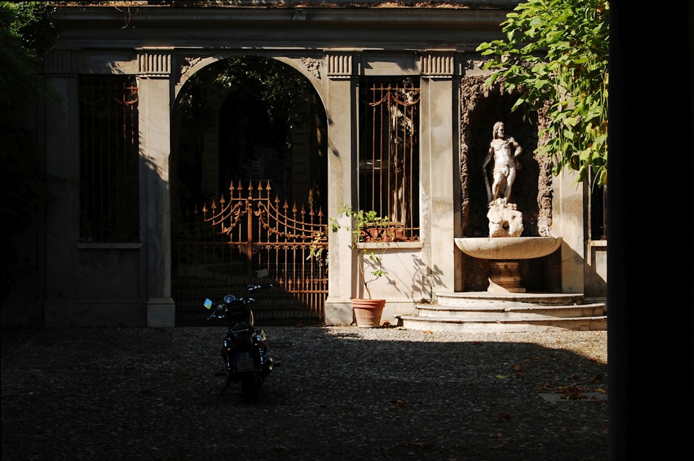 a motorcycle parked in front of a gated entrance