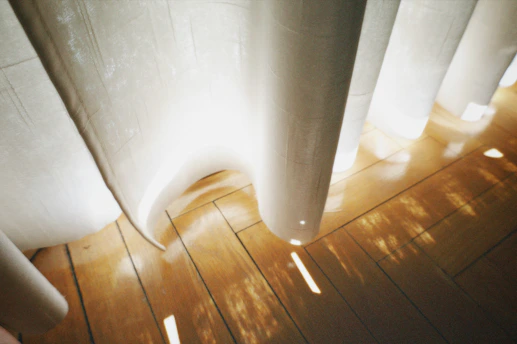 Soft morning light filtering through sheer curtains onto a quiet meditation space.