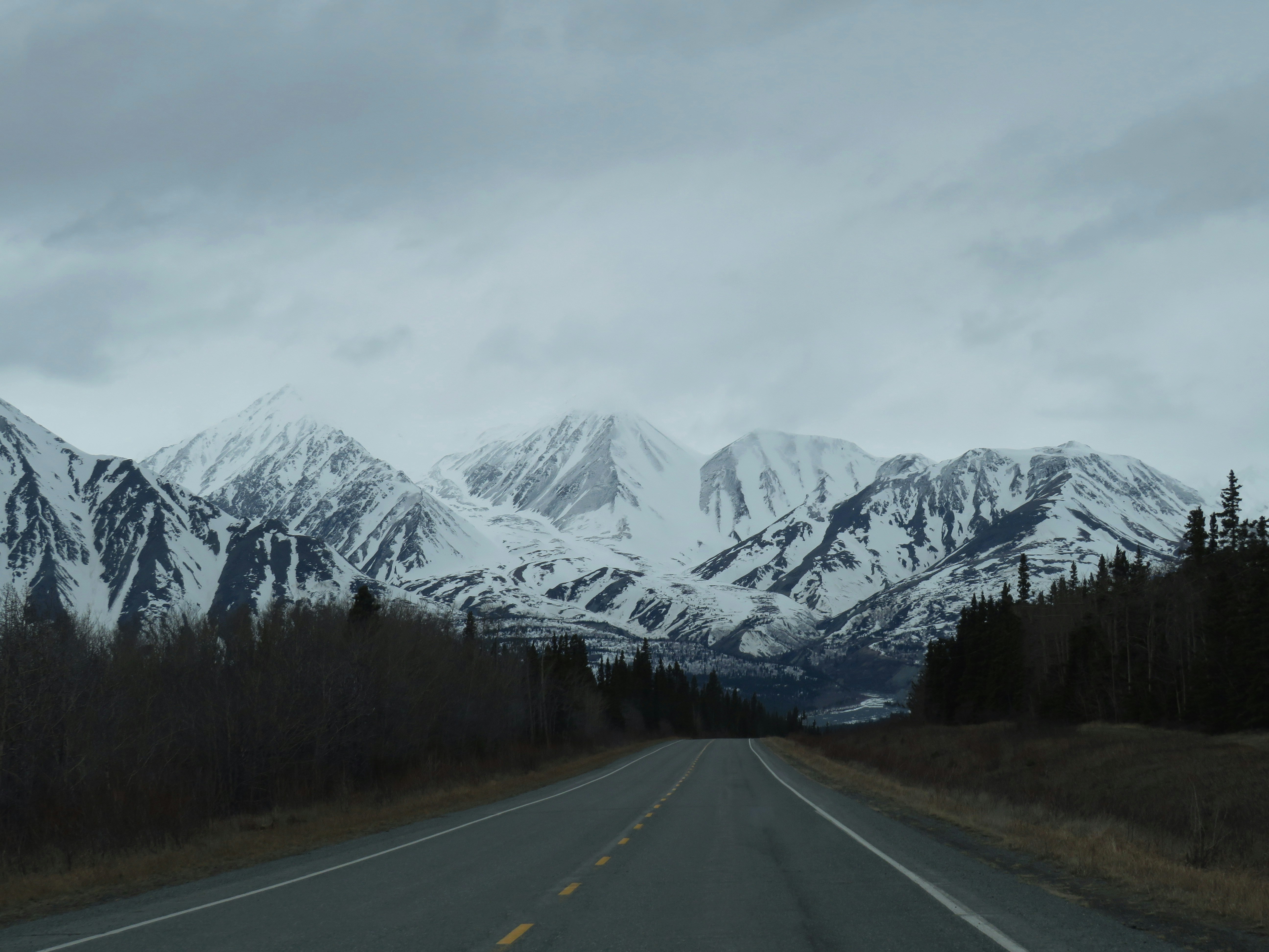 a road with snow covered mountains, 