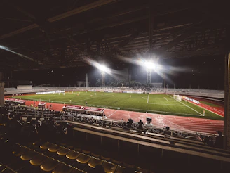 An athlete wearing a fully customized football kit, running on a stadium field under bright lights.