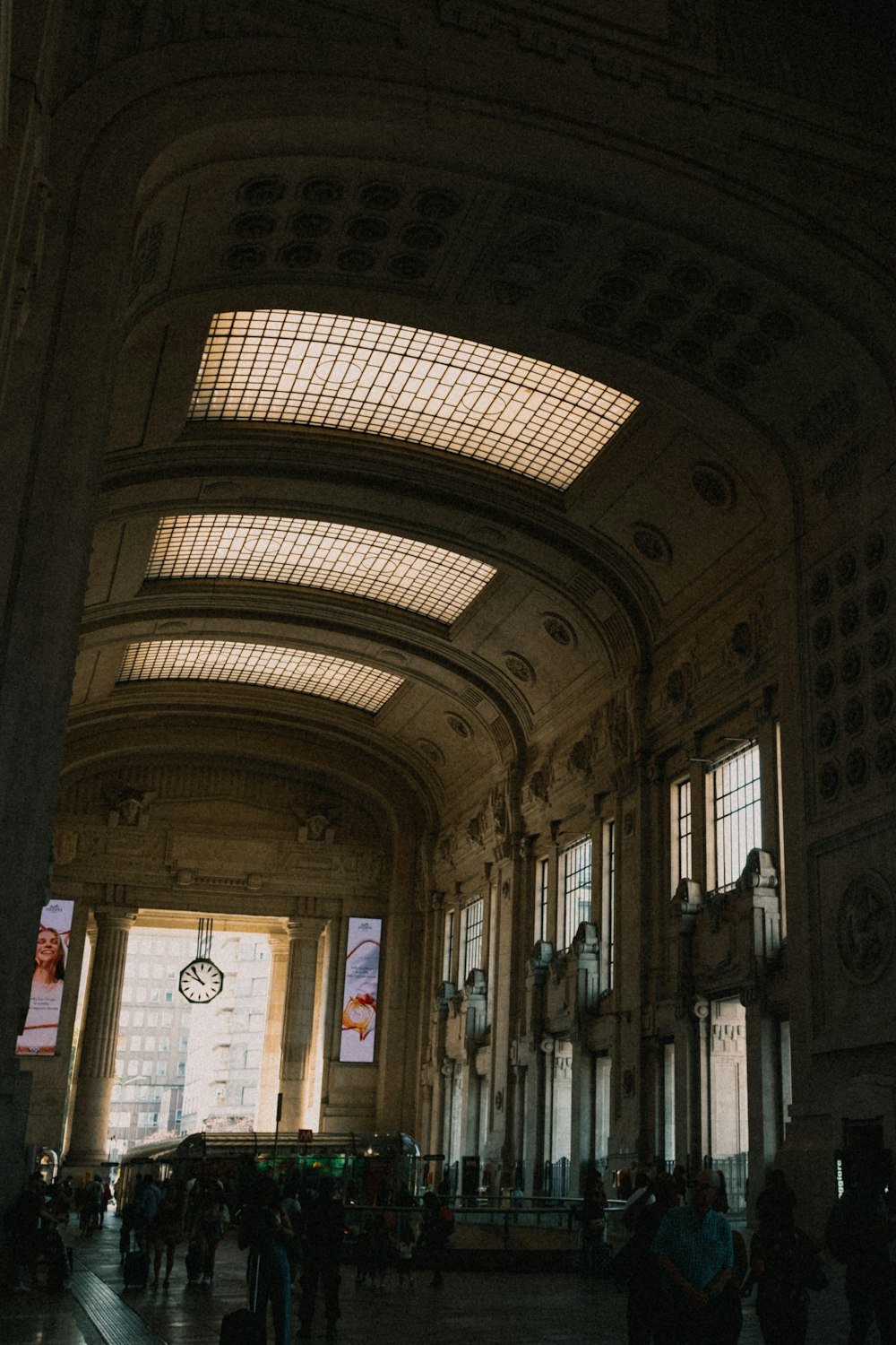 a large clock hangs from the ceiling