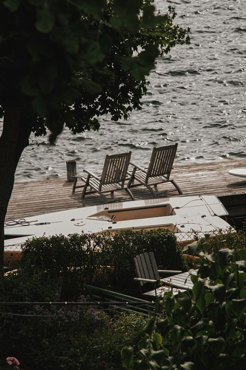 chairs and a surfboard on a dock