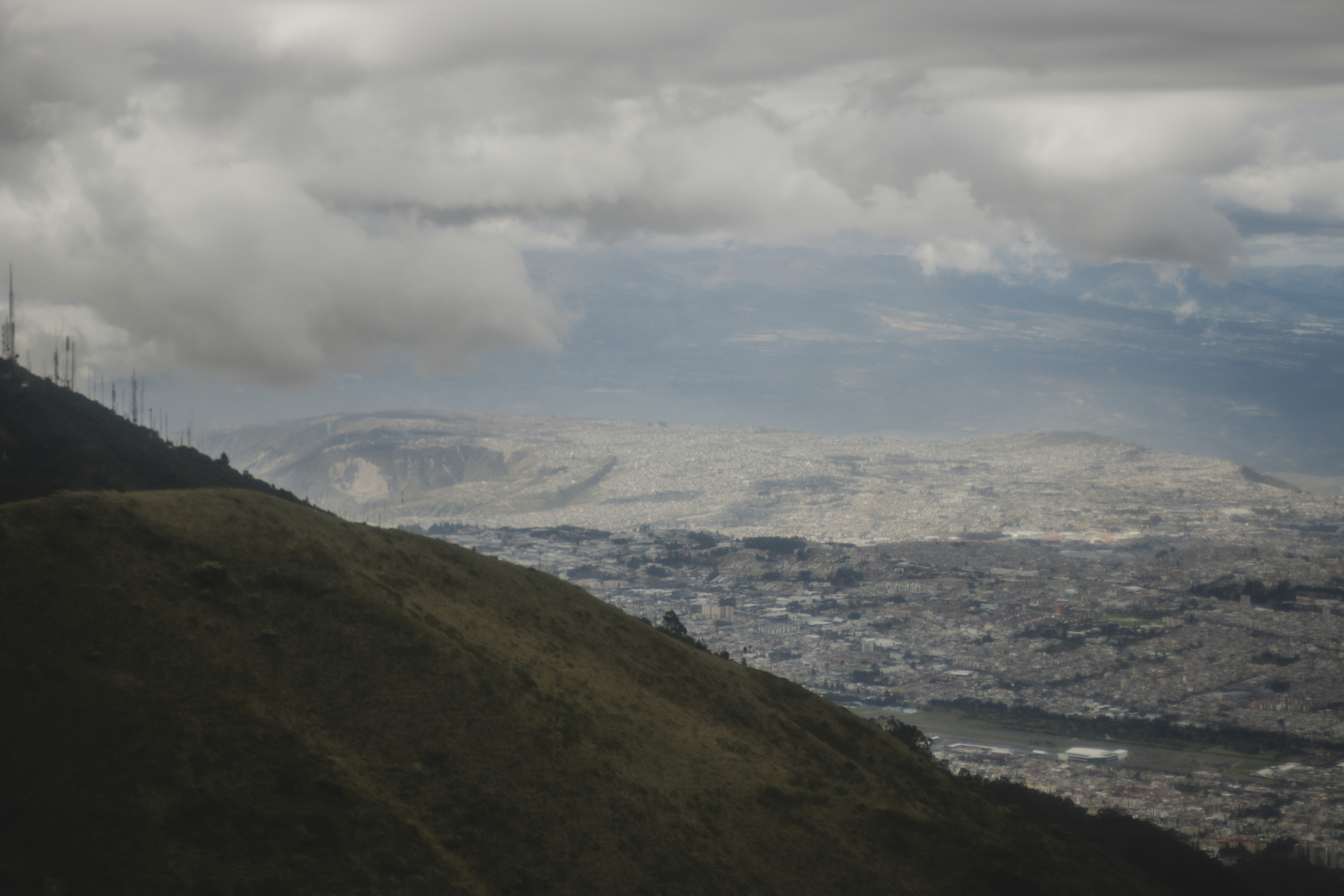 a landscape with hills and a body of water in the back - Quito