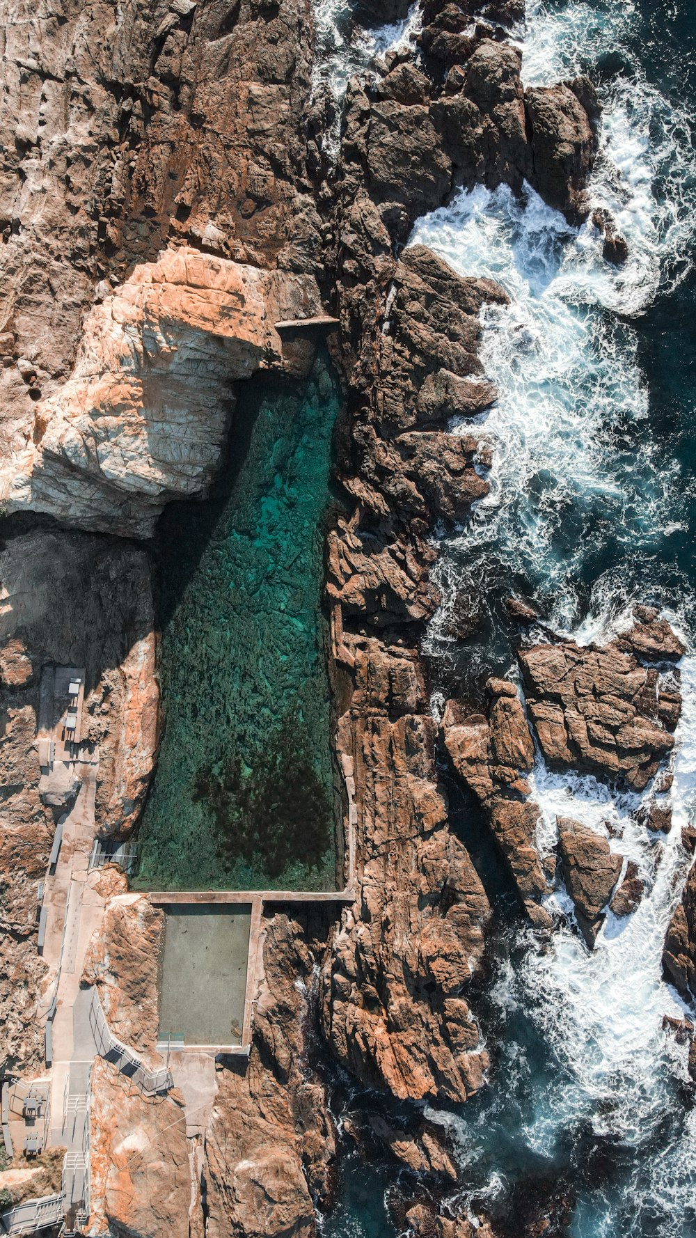 a large rock cliff with a waterfall