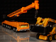 Tonka toy cranes and bulldozers set against a backdrop of building blocks.