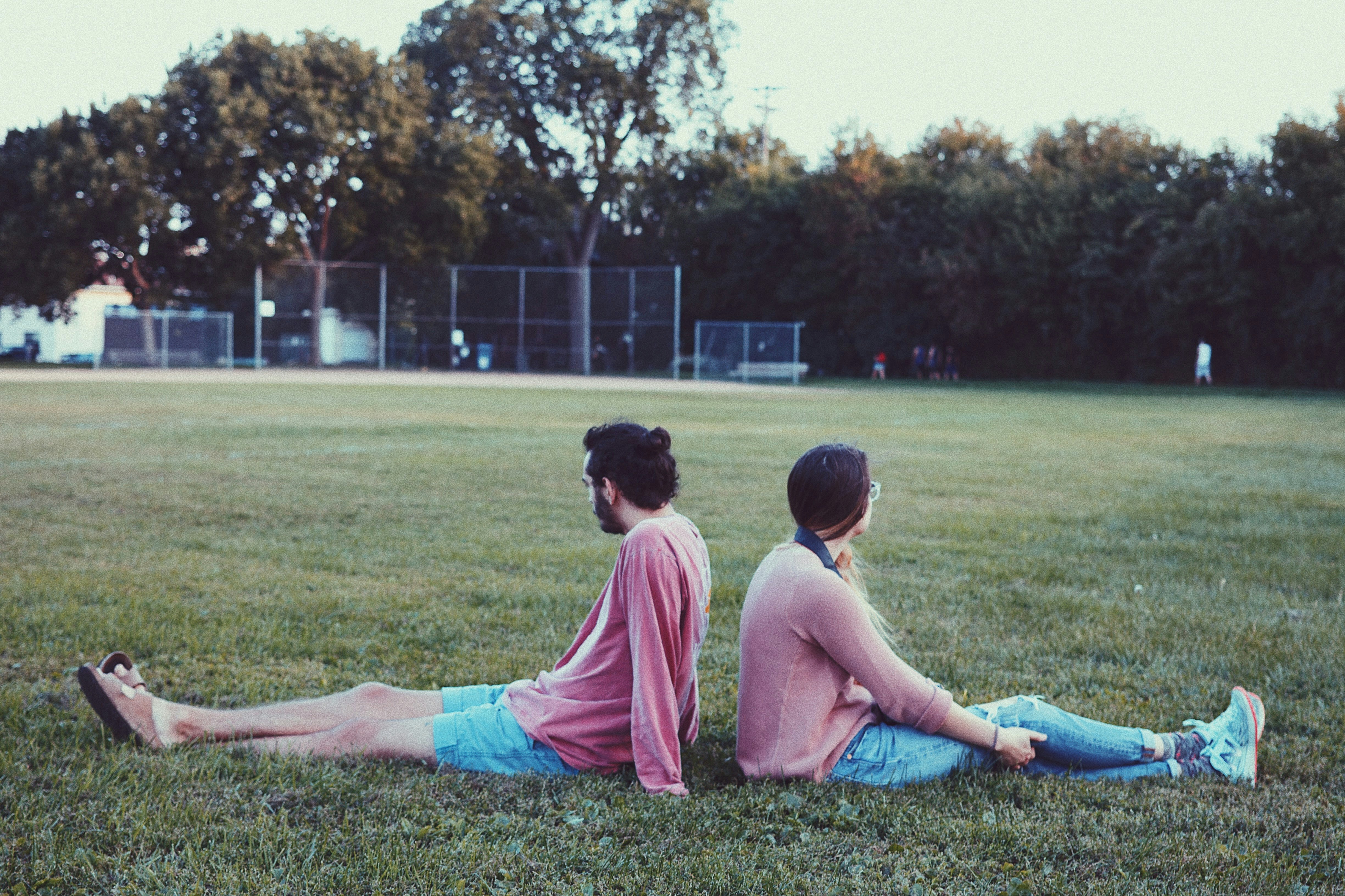 two people sitting on the grass