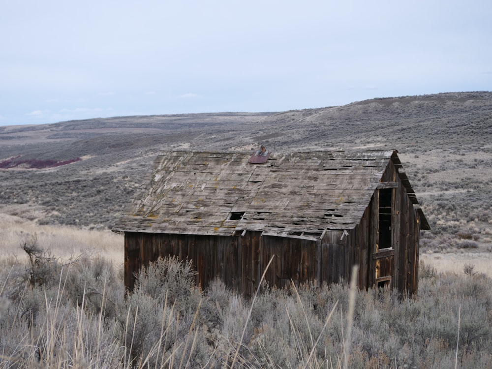 a wooden building in a field