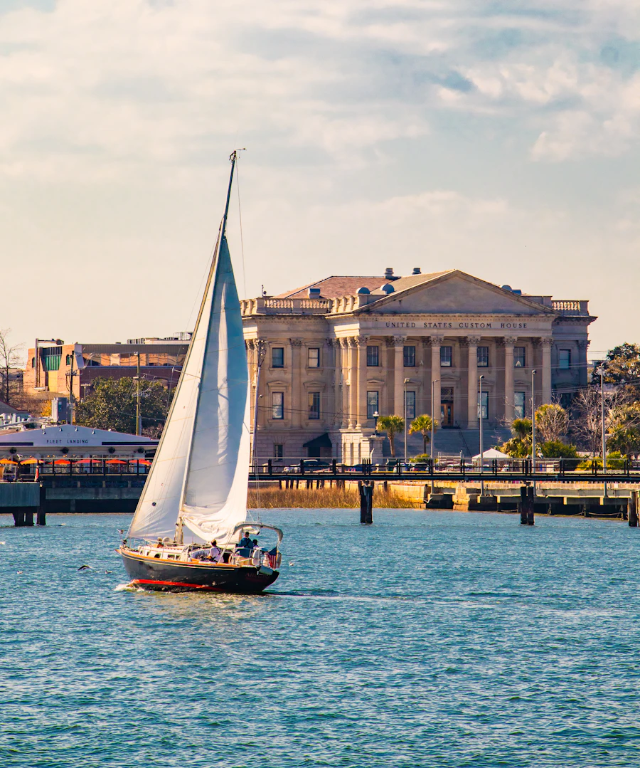 A sailboat passing the Charleston waterfront