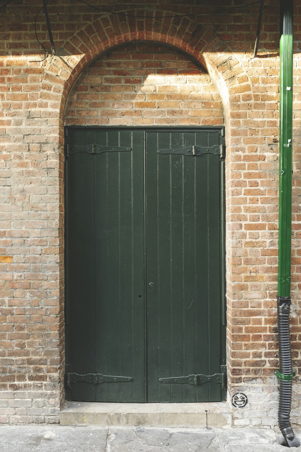 a black door in a brick wall