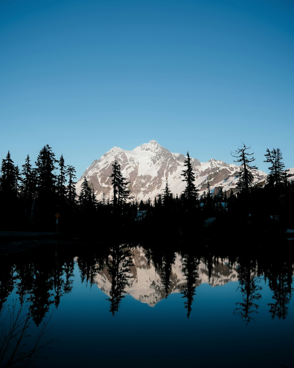 a snowy mountain reflected in water