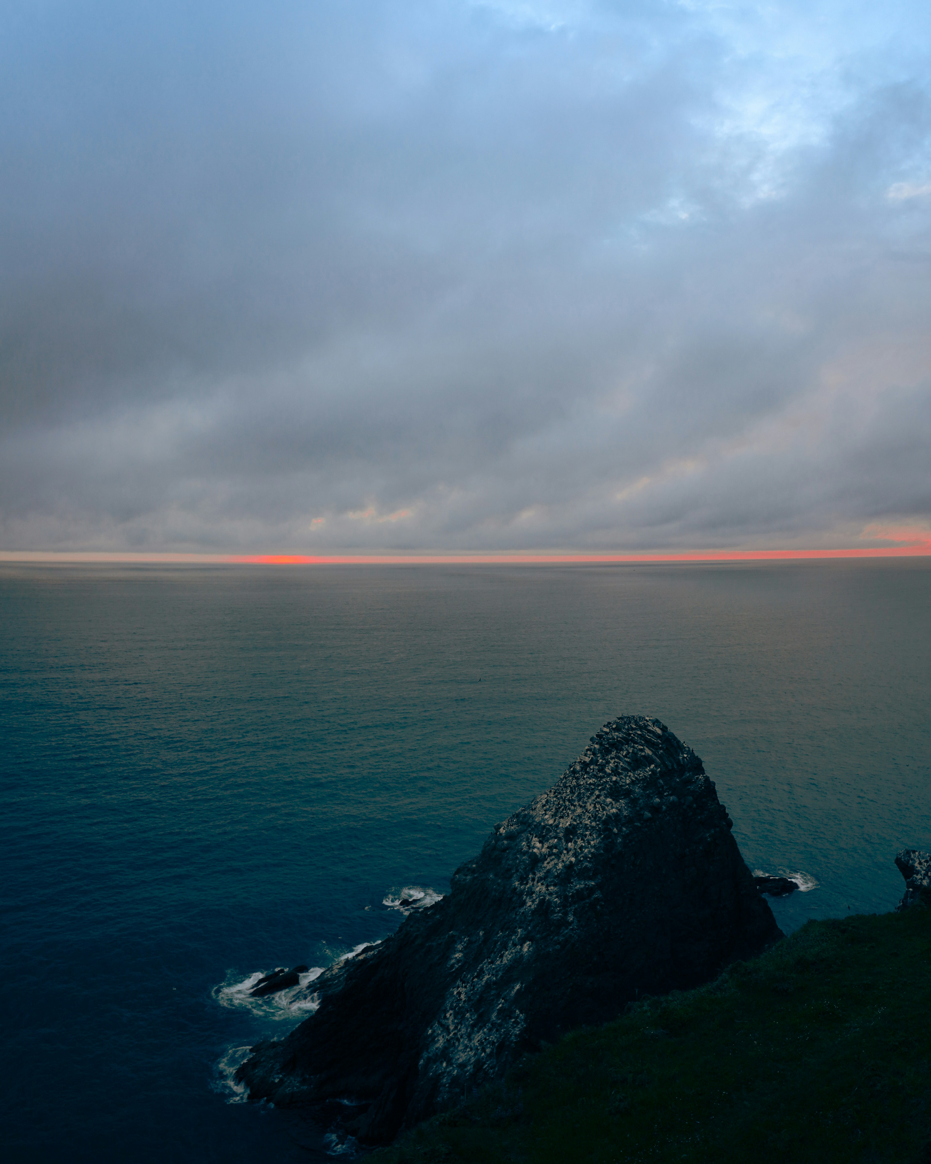 a body of water with a rock in the middle