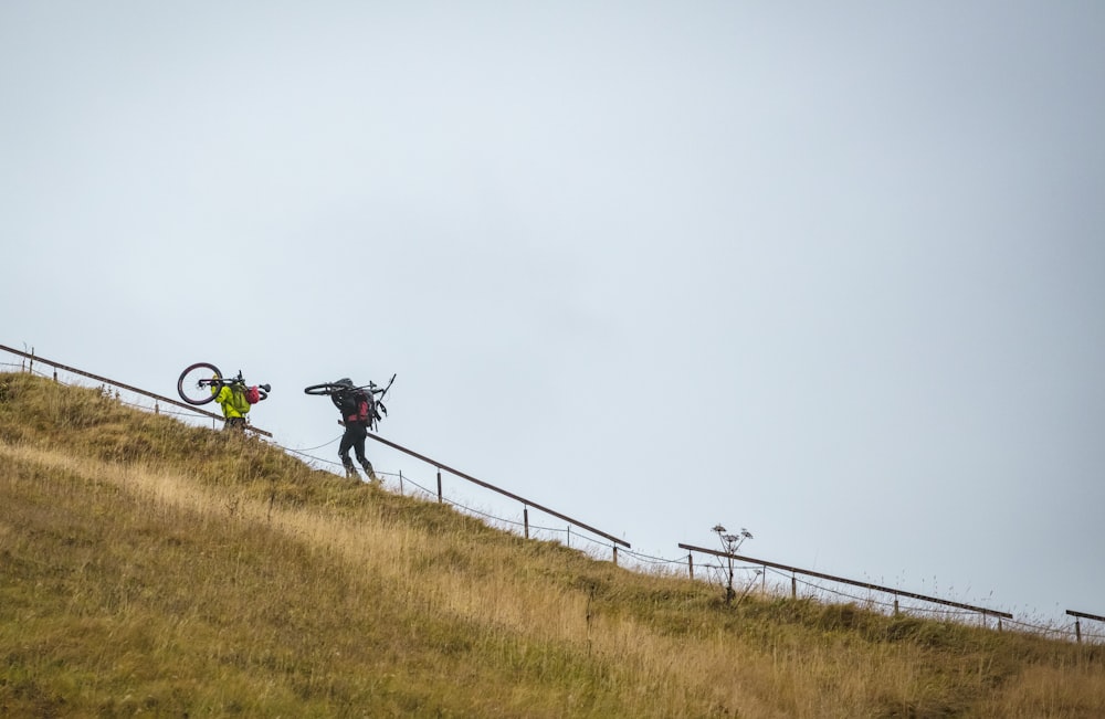 a person with a bike on a grassy hill